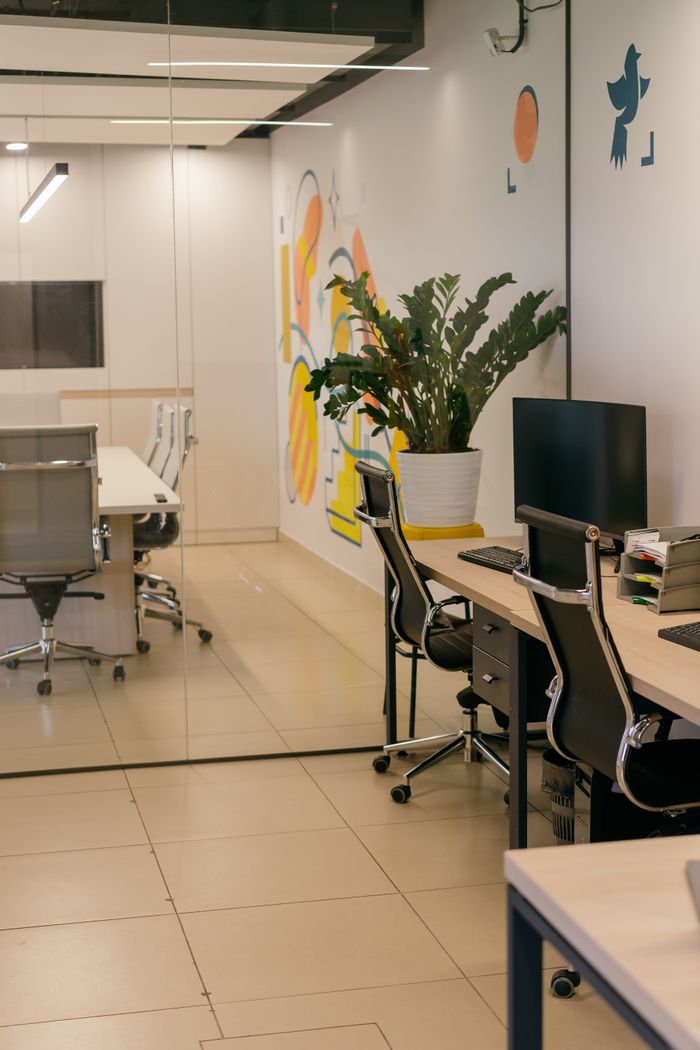 services-04 Spacious and contemporary office interior with glass partitions, stylish furniture, and vibrant wall art.
